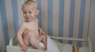 Kinderarztpraxis München Baby sitzend